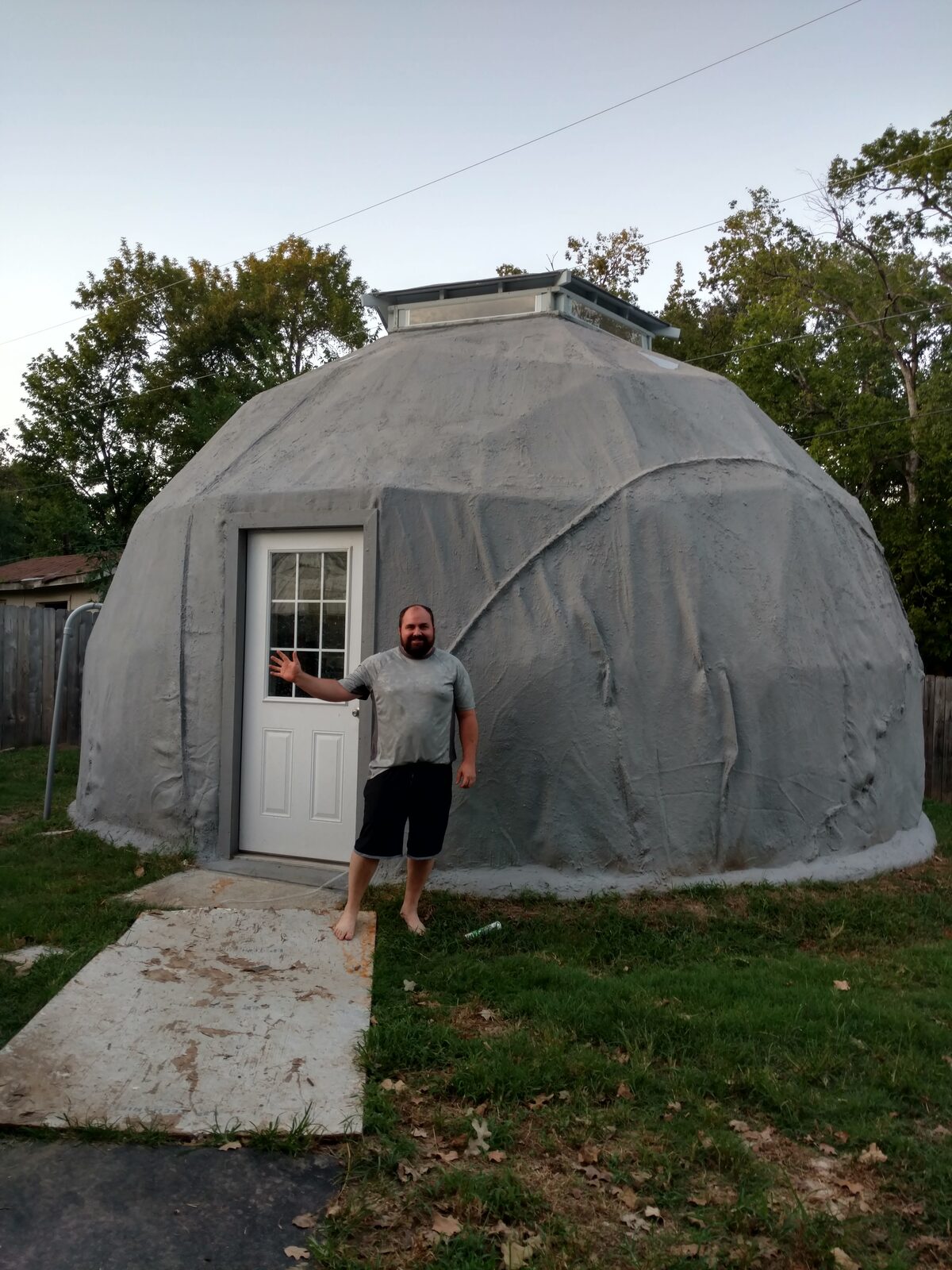 Person standing at the dome door at dusk for scale